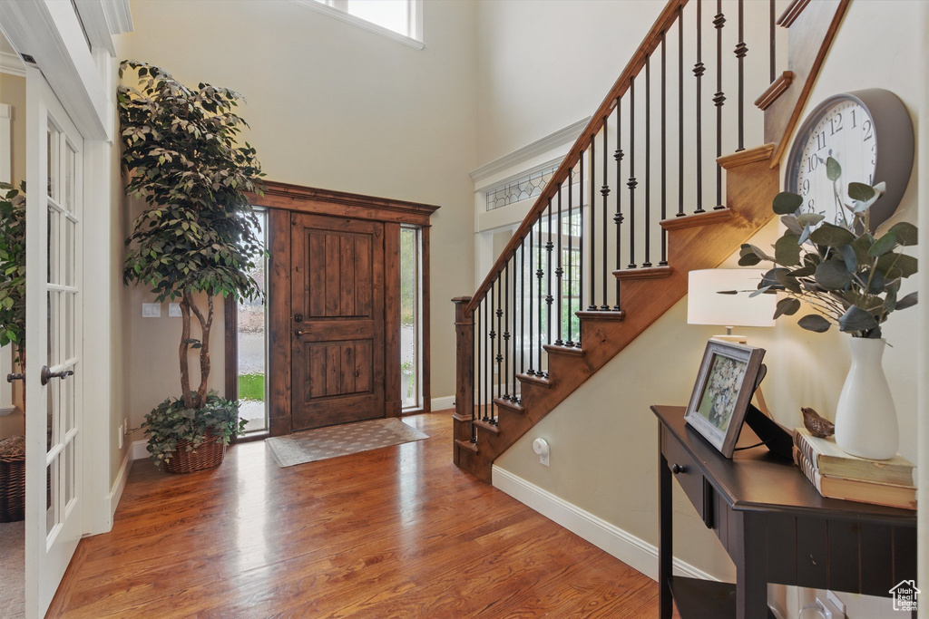 Entrance foyer featuring a healthy amount of sunlight, stairs, and wood finished floors