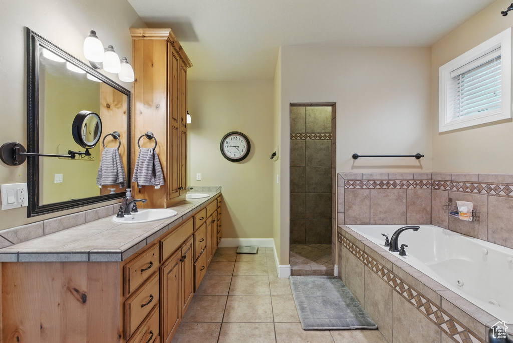 Full bathroom featuring a whirlpool tub, a sink, tile patterned floors, and double vanity