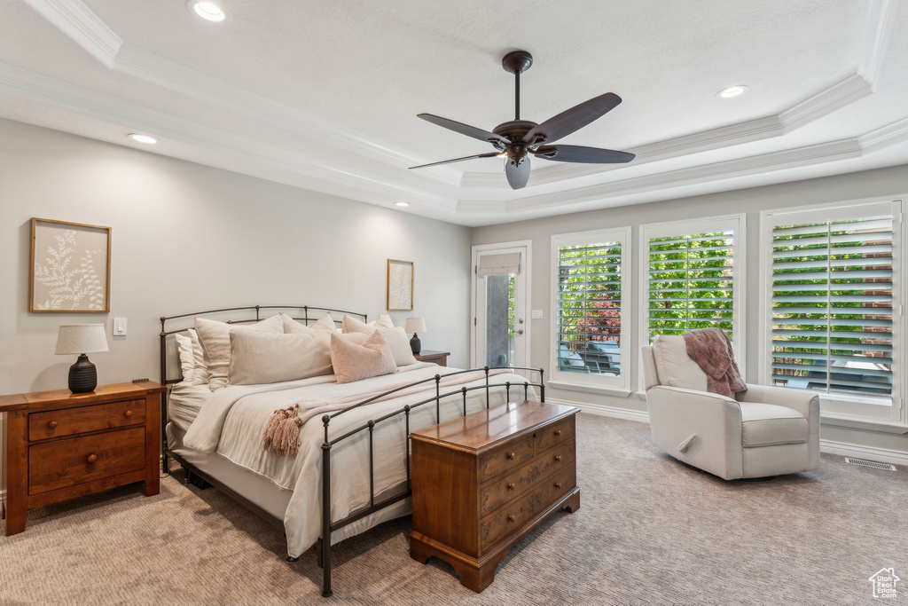 Bedroom featuring carpet flooring, recessed lighting, a tray ceiling, and crown molding