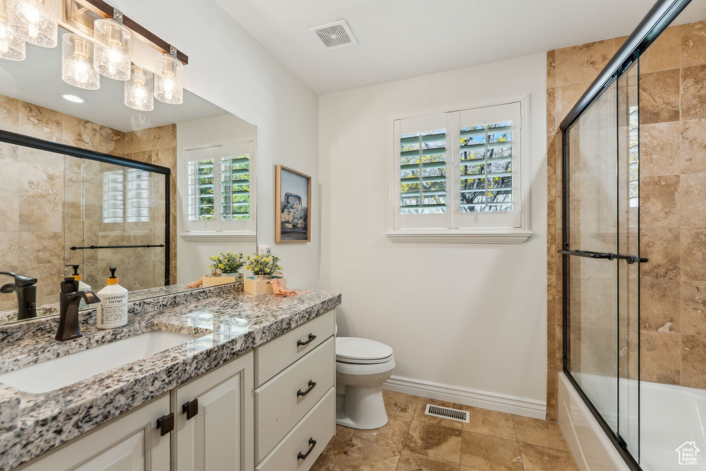 Bathroom featuring vanity, baseboards, toilet, and visible vents