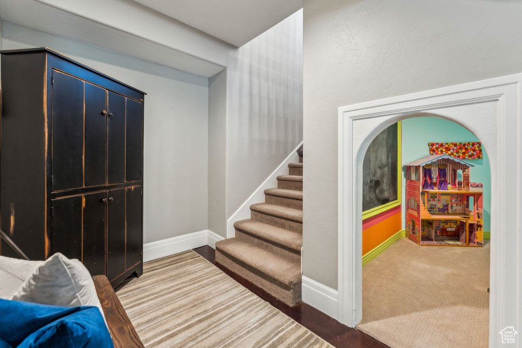 Entrance foyer with stairway, baseboards, and carpet flooring