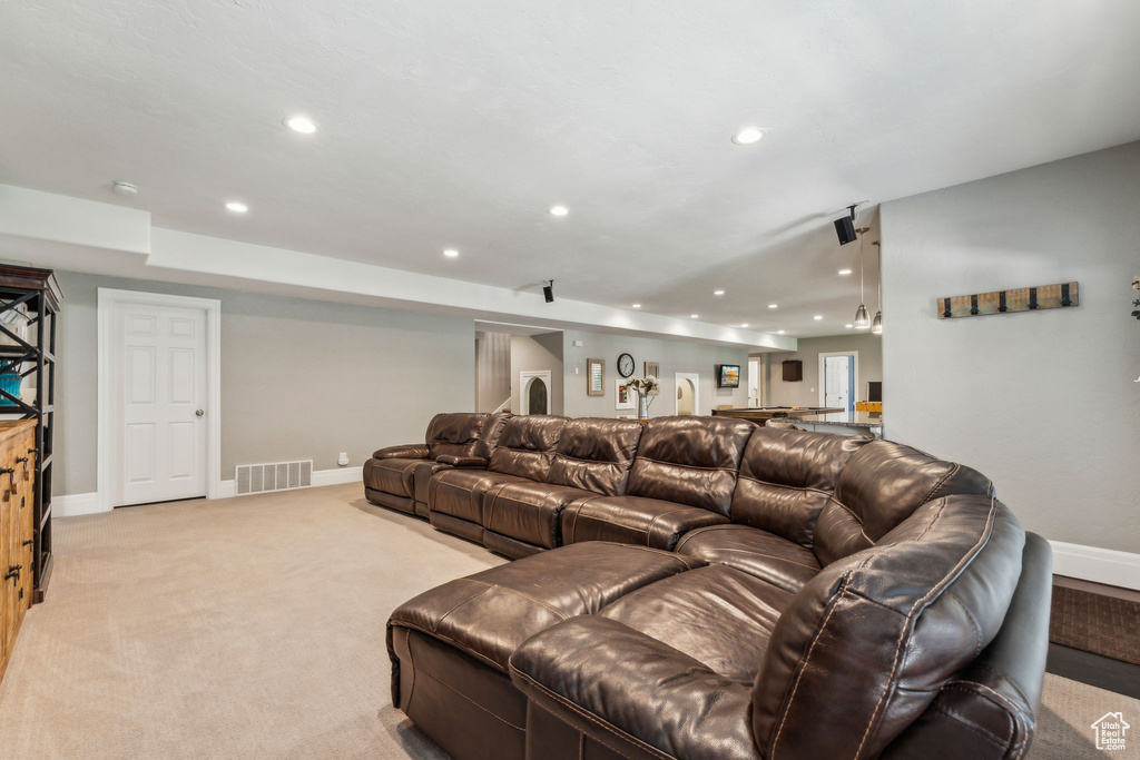 Living area featuring recessed lighting, baseboards, visible vents, and light colored carpet