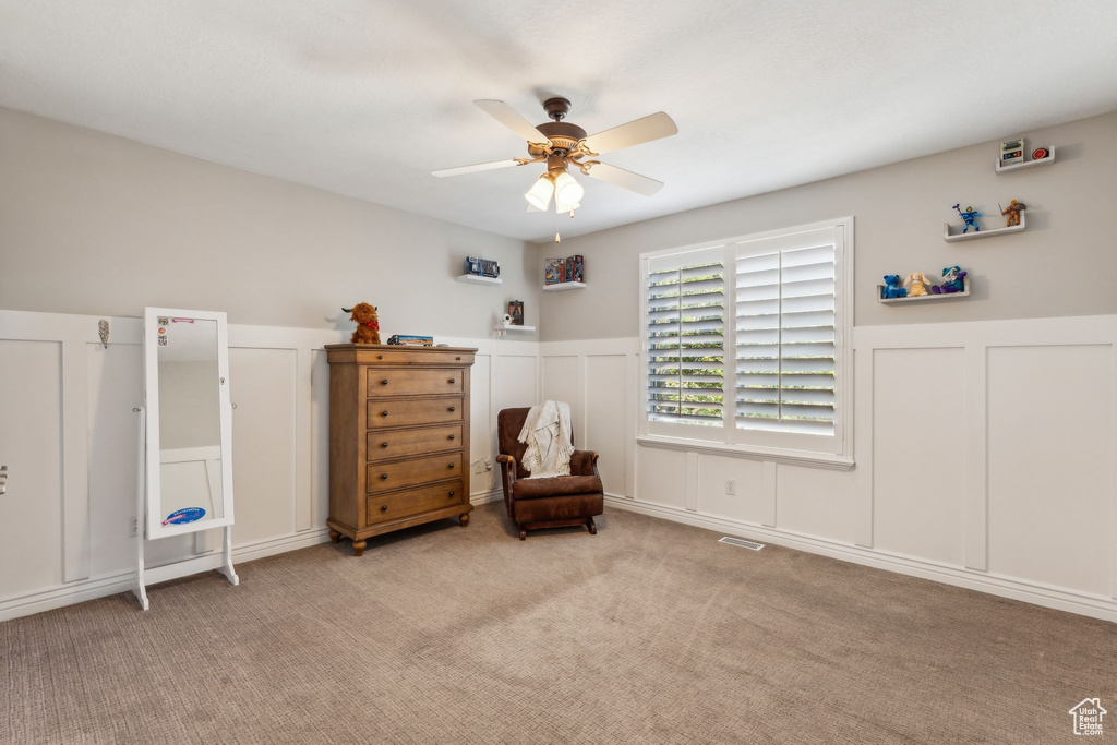 Bedroom with wainscoting, a decorative wall, and light colored carpet