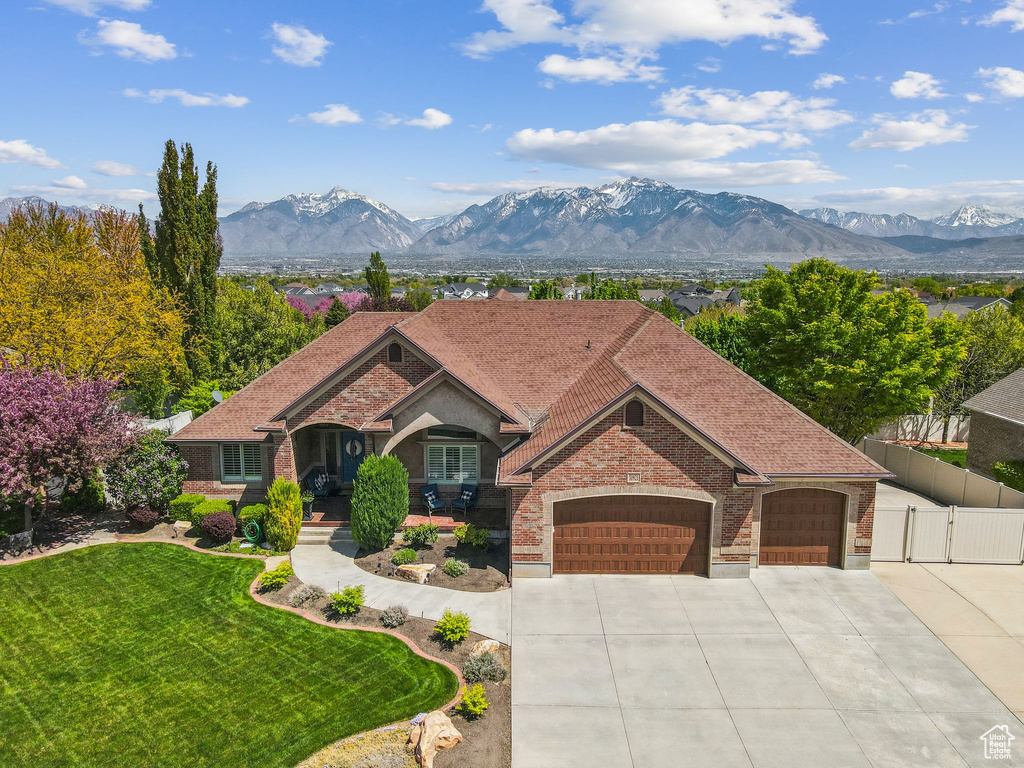 View of front of property with fence, a front yard, a gate, an attached garage, and driveway