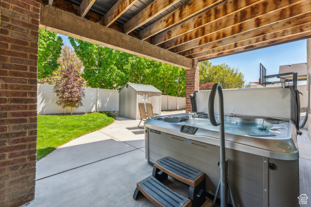 View of patio with an outbuilding, a shed, and a fenced backyard