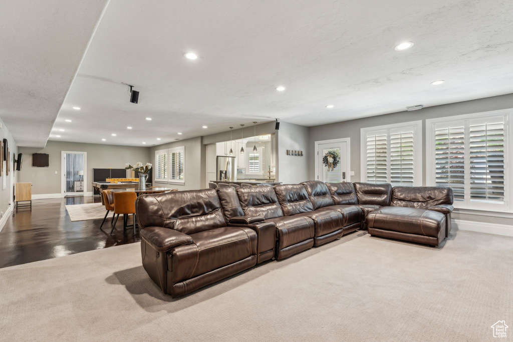 Carpeted living area featuring recessed lighting and baseboards