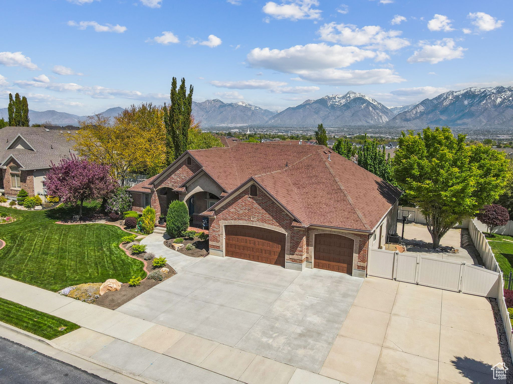 Ranch-style home featuring fence, an attached garage, a front lawn, a gate, and driveway