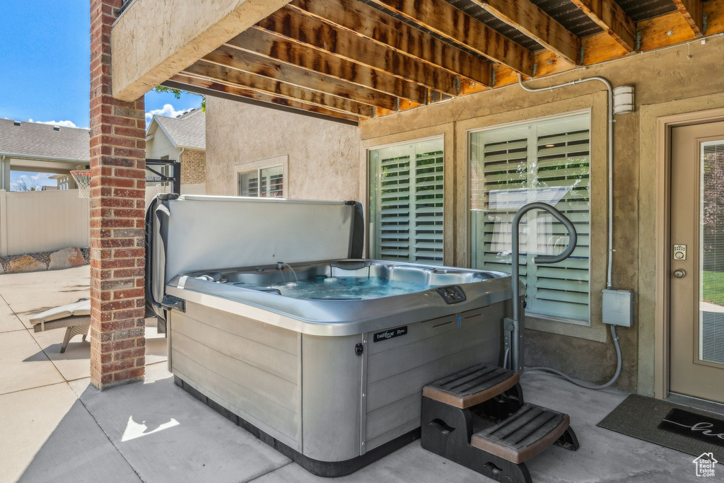 View of patio / terrace with a hot tub and fence
