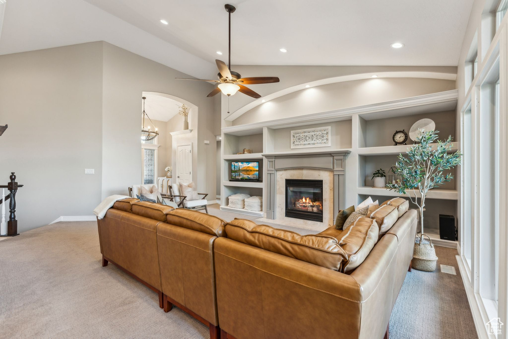 Living area with ceiling fan, built in shelves, light carpet, and a fireplace