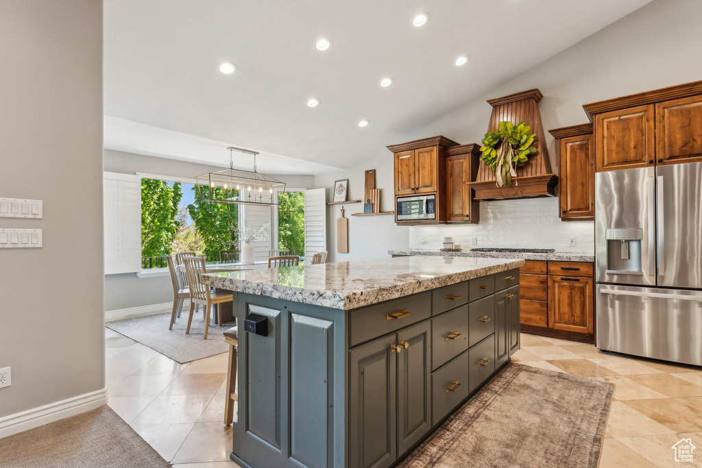 Kitchen with brown cabinetry, a center island, tasteful backsplash, stainless steel appliances, and recessed lighting