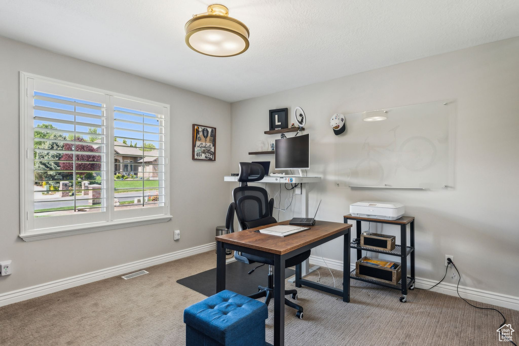 Office area featuring baseboards, carpet flooring, and visible vents