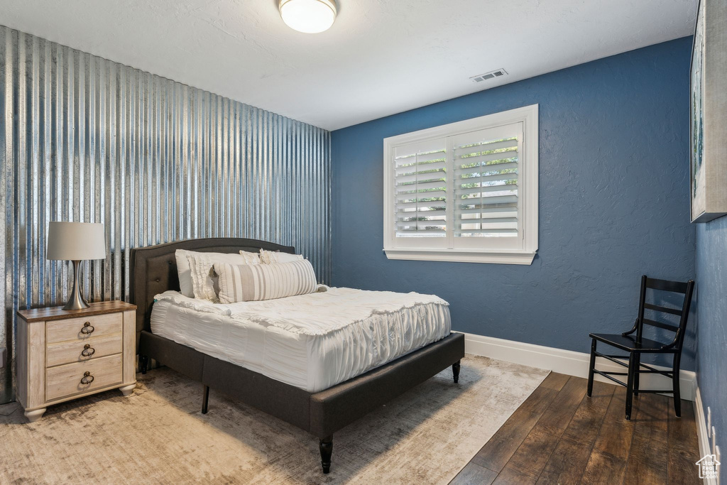 Bedroom with baseboards, wood-type flooring, and visible vents