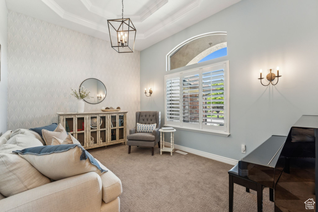 Sitting room featuring crown molding, carpet floors, baseboards, a raised ceiling, and a chandelier