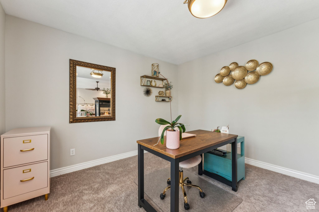 Home office with baseboards and carpet