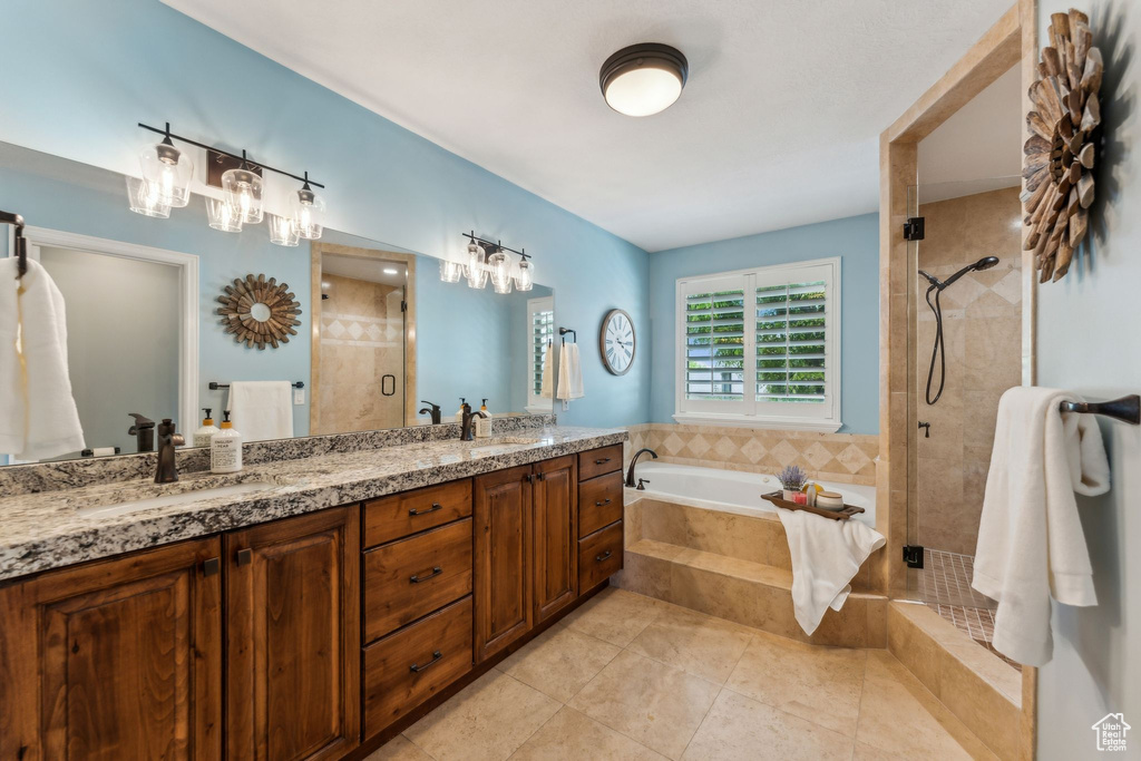 Bathroom with double vanity, tile patterned floors, a bath, a shower stall, and a sink