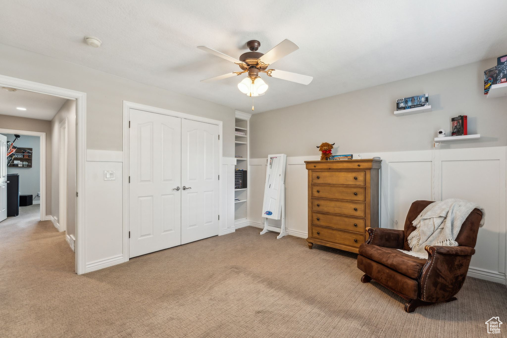 Sitting room featuring ceiling fan and light carpet