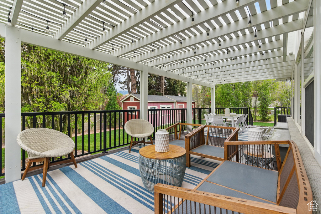 Wooden deck featuring outdoor dining area and a pergola
