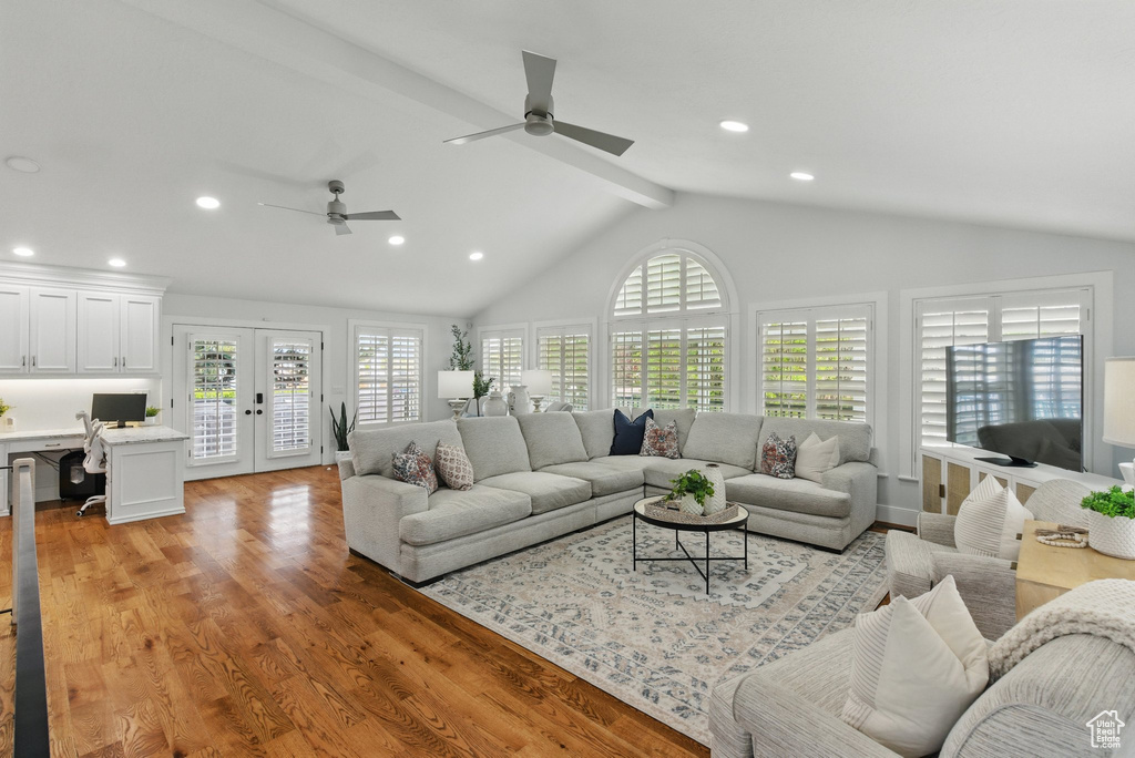Living room with recessed lighting, beam ceiling, french doors, and light wood-type flooring