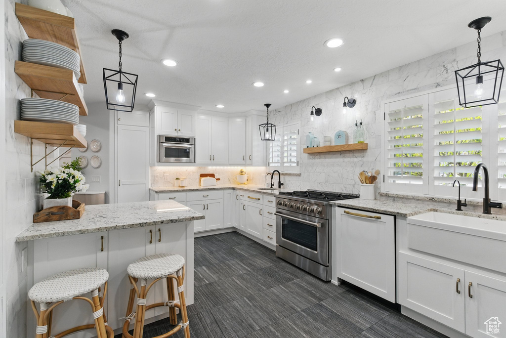 Kitchen featuring a sink, open shelves, backsplash, and stainless steel appliances