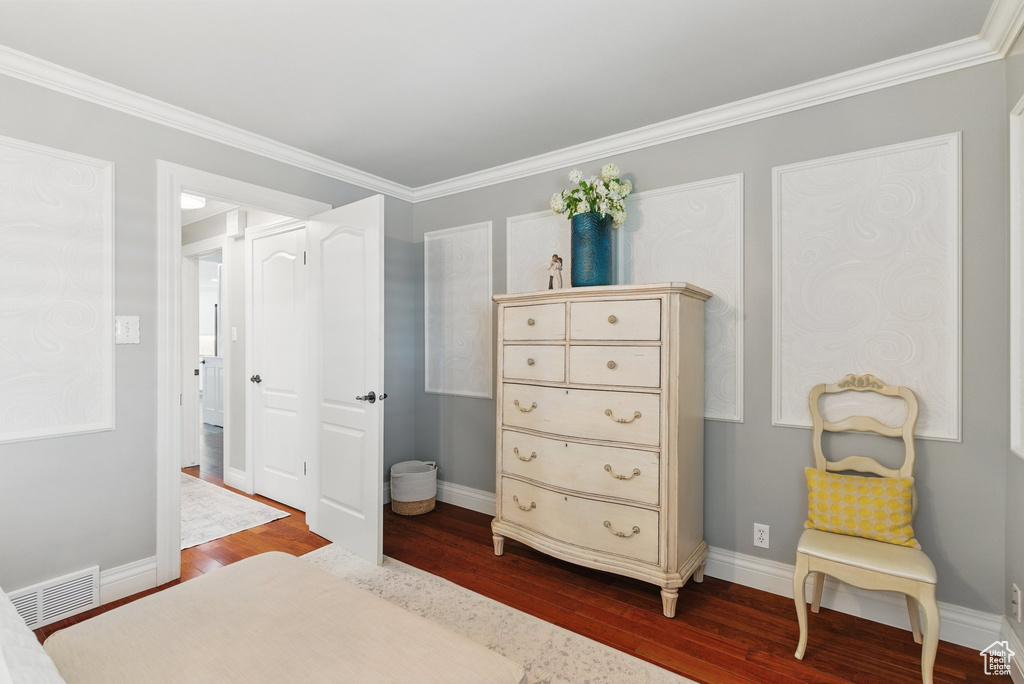Bedroom featuring baseboards, visible vents, ornamental molding, and dark wood-type flooring