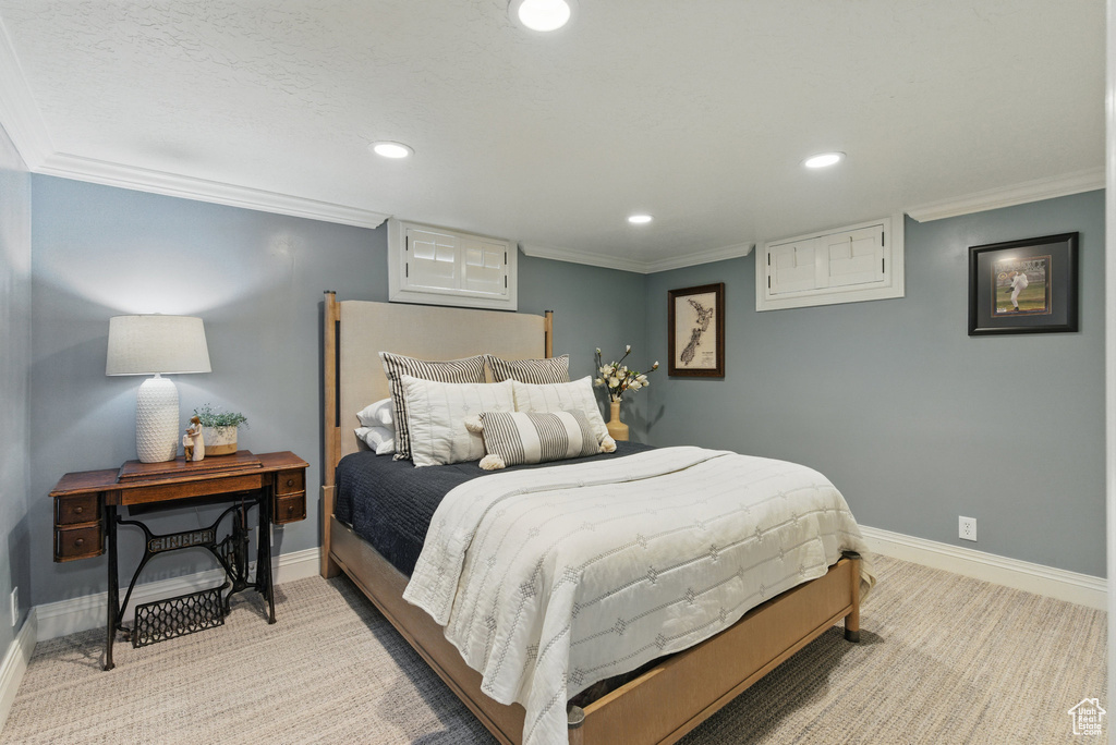 Bedroom with light colored carpet, ornamental molding, and baseboards