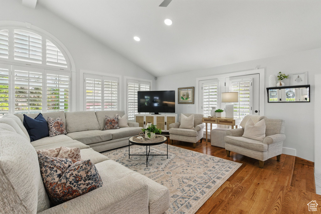 Living room with high vaulted ceiling, a ceiling fan, recessed lighting, and wood finished floors