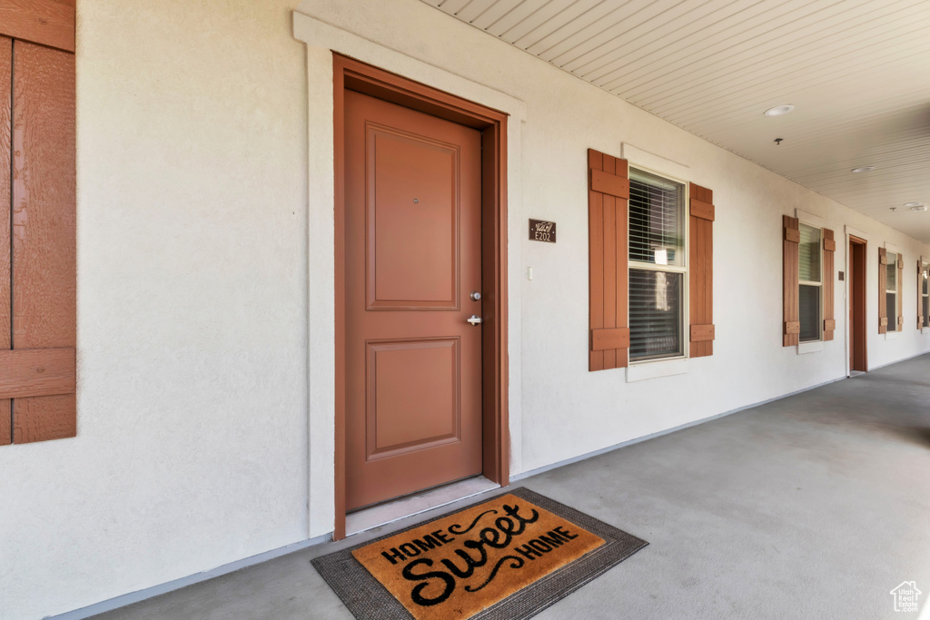 Doorway to property featuring a porch and stucco siding