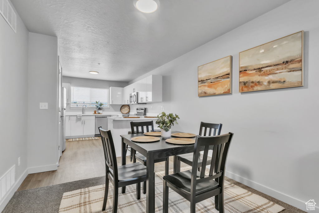 Dining area featuring visible vents, a textured ceiling, and baseboards