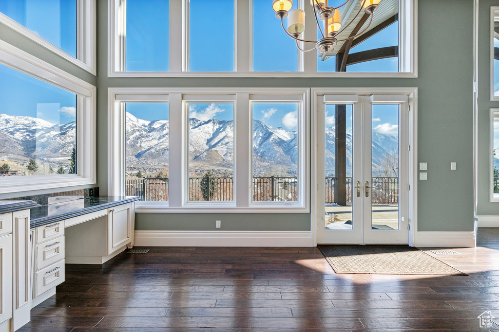 Unfurnished sunroom with french doors, a mountain view, and a chandelier