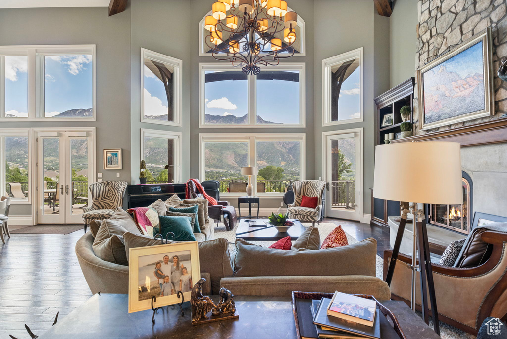 Living area featuring a high ceiling, an inviting chandelier, french doors, and a fireplace
