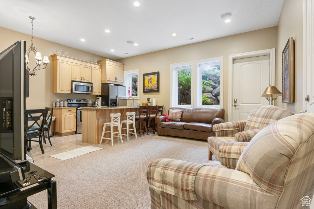 Living area featuring recessed lighting, a notable chandelier, and light carpet