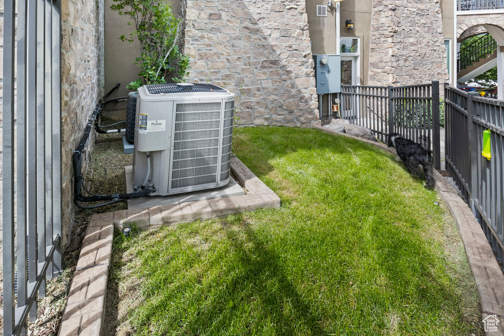 View of yard featuring central air condition unit and fence