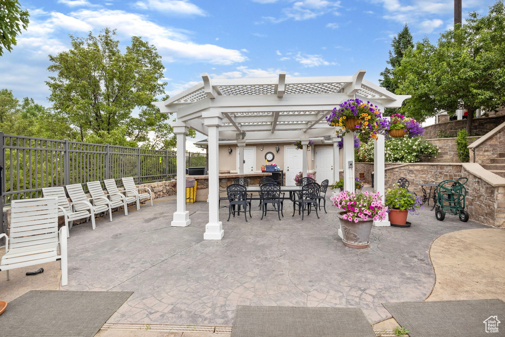 View of patio / terrace with a fenced backyard, outdoor dry bar, a pergola, and area for grilling