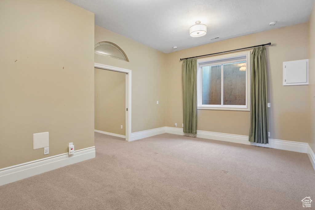 Spare room featuring baseboards and light carpet