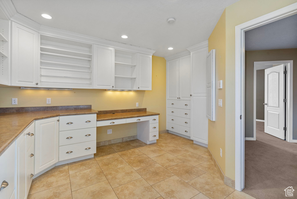 Kitchen featuring recessed lighting, open shelves, built in desk, and white cabinets