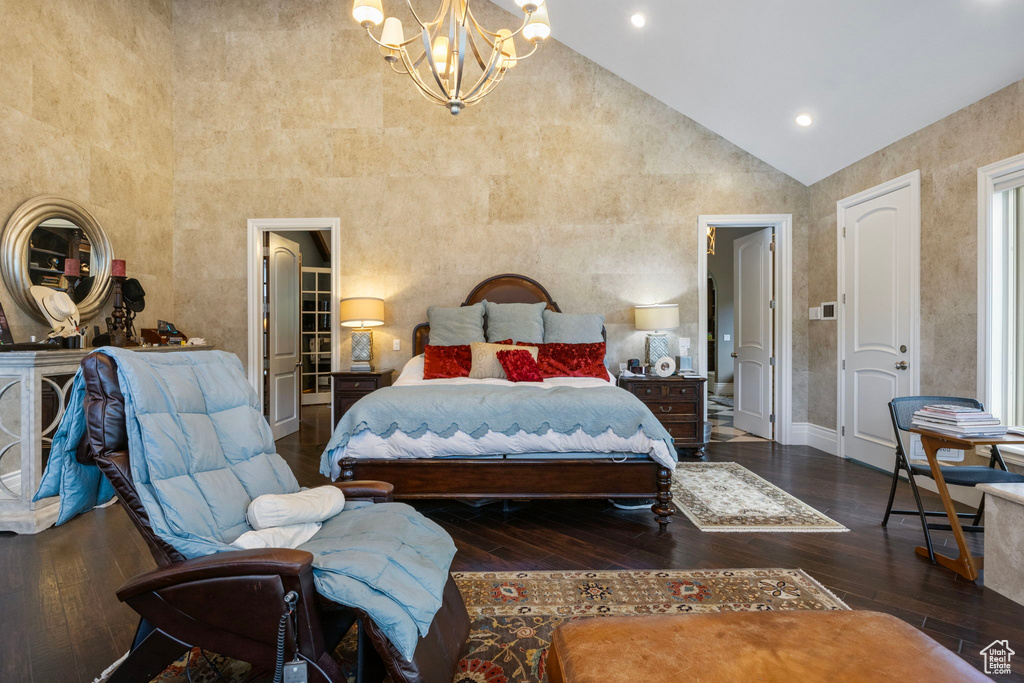 Bedroom with high vaulted ceiling, baseboards, hardwood / wood-style flooring, and a chandelier