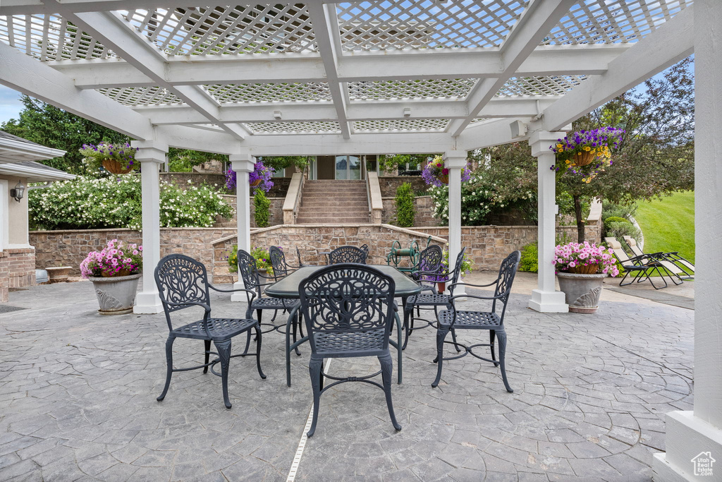 View of patio with outdoor dining space and a pergola