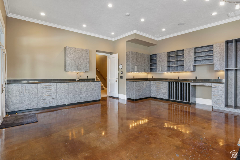 Kitchen featuring dark countertops, open shelves, baseboards, visible vents, and ornamental molding