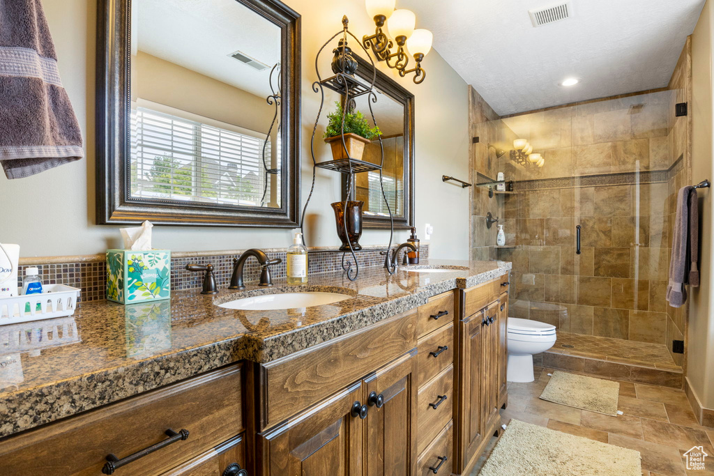 Full bathroom with a sink, double vanity, and visible vents