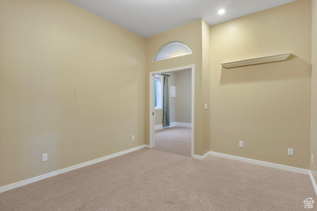 Empty room with light colored carpet, recessed lighting, and baseboards