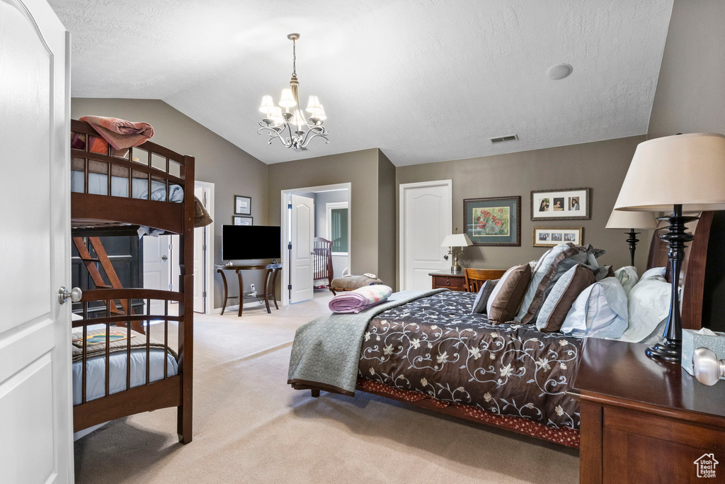 Bedroom with visible vents, lofted ceiling, light colored carpet, a textured ceiling, and a chandelier