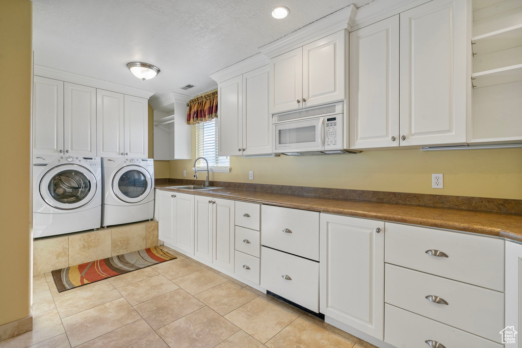 Laundry room featuring visible vents, a sink, cabinet space, independent washer and dryer, and light tile patterned floors