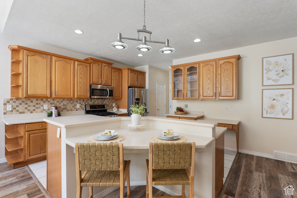 Kitchen featuring open shelves, appliances with stainless steel finishes, and light countertops