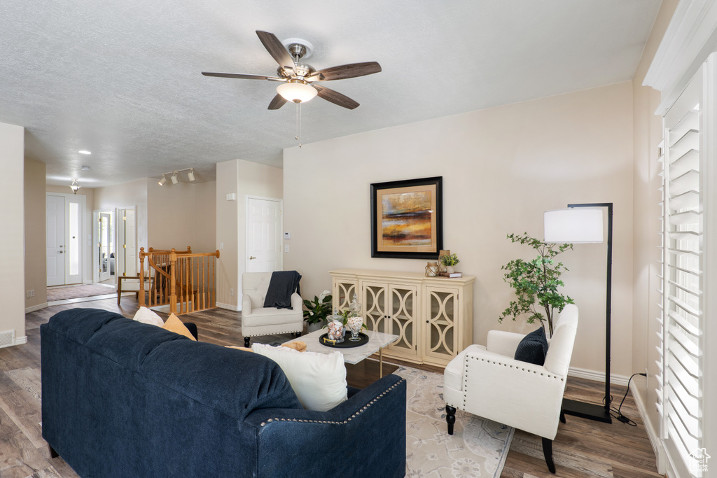 Living room featuring baseboards, ceiling fan, and wood finished floors
