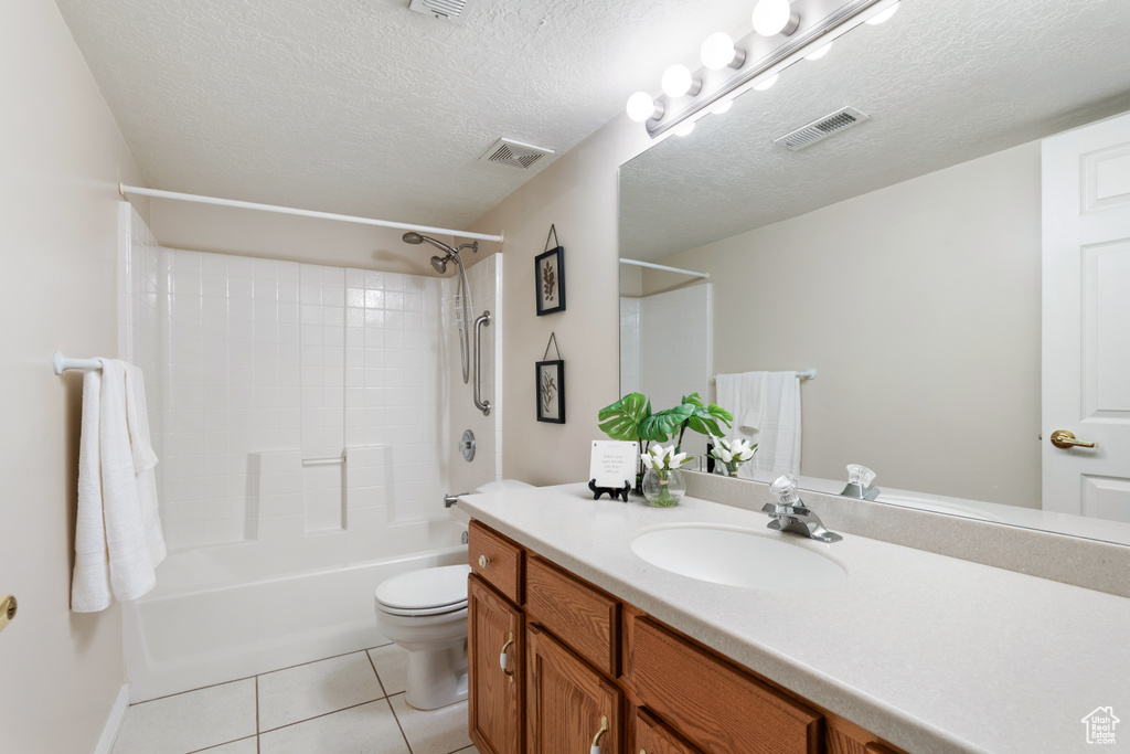 Full bath featuring tile patterned floors, vanity, toilet, and visible vents