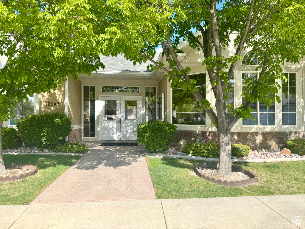 Property entrance featuring a yard and stone siding