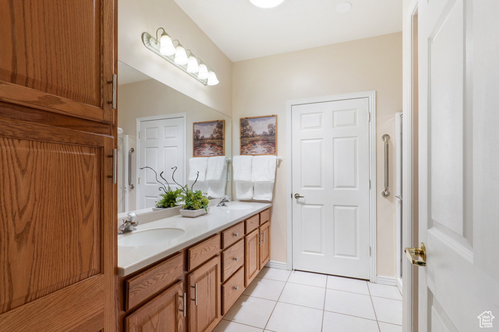 Bathroom featuring double vanity, a sink, and tile patterned floors