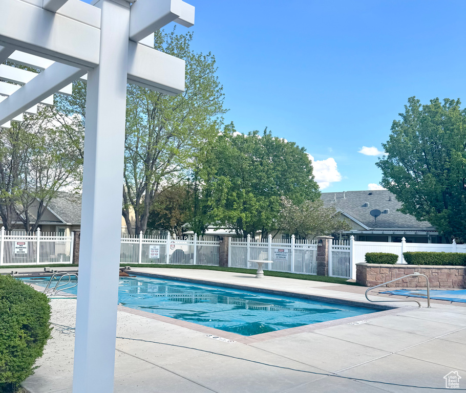 Pool featuring fence and a patio area
