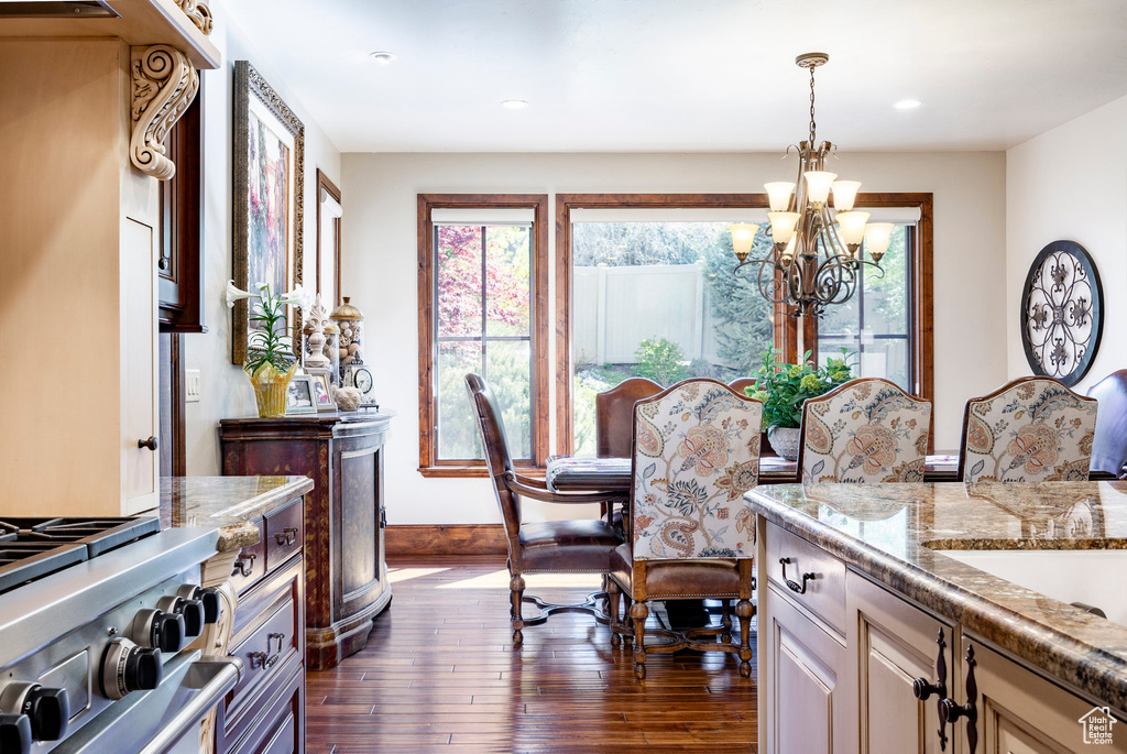 Dining space featuring recessed lighting, baseboards, an inviting chandelier, and dark wood-type flooring