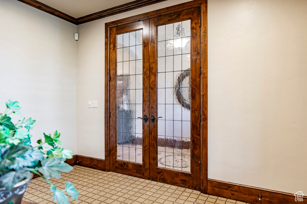 Doorway featuring baseboards, ornamental molding, and french doors